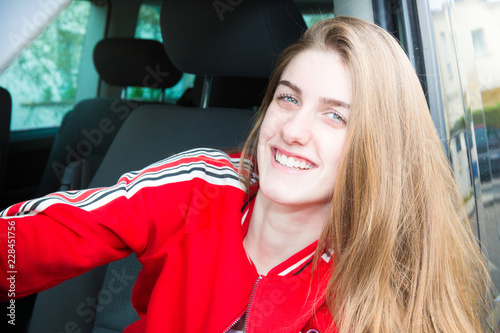 pretty blonde smiling driver girl in van car in summer