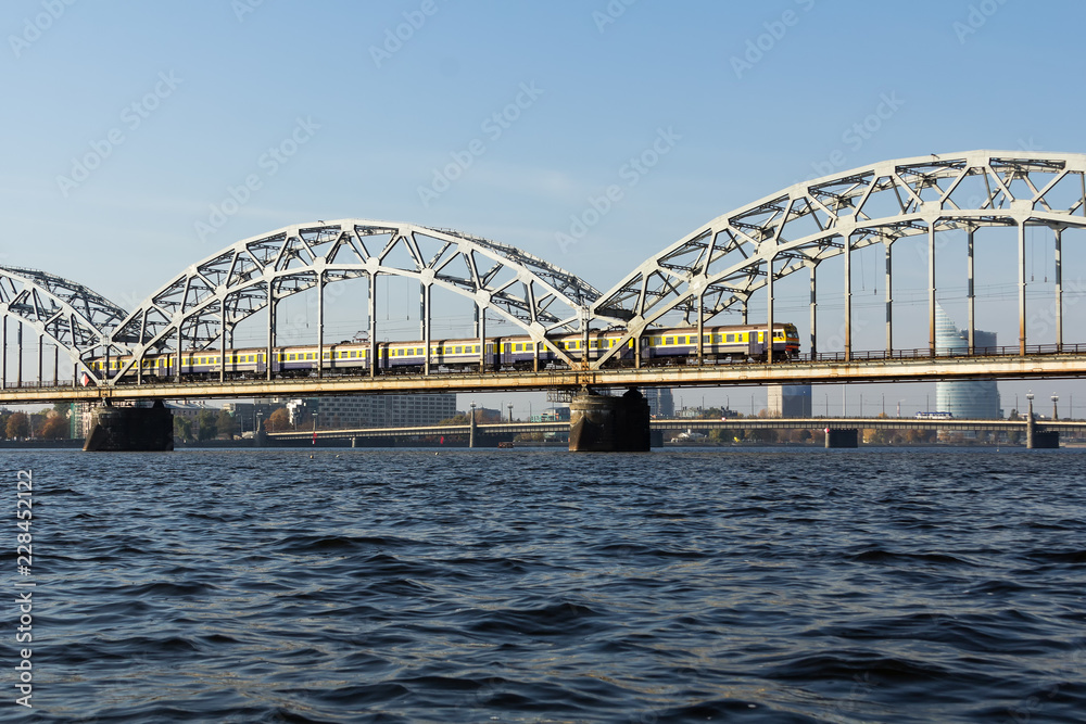Railway bridge in Riga over the Daugava River in the fall in October on a sunny day Railway bridge in Riga over the Daugava River in the fall in October on a sunny day