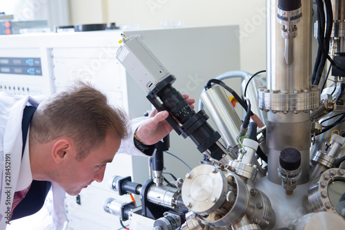 laboratory specialist examines the data obtained on a special apparatus for analyzing samples photo