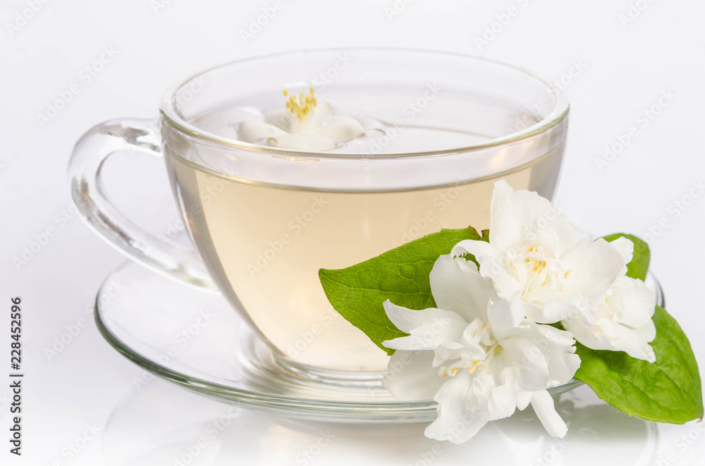 Glass cup of Tea with jasmine flowers and leaves Glass cup of Tea with jasmine flowers and leaves