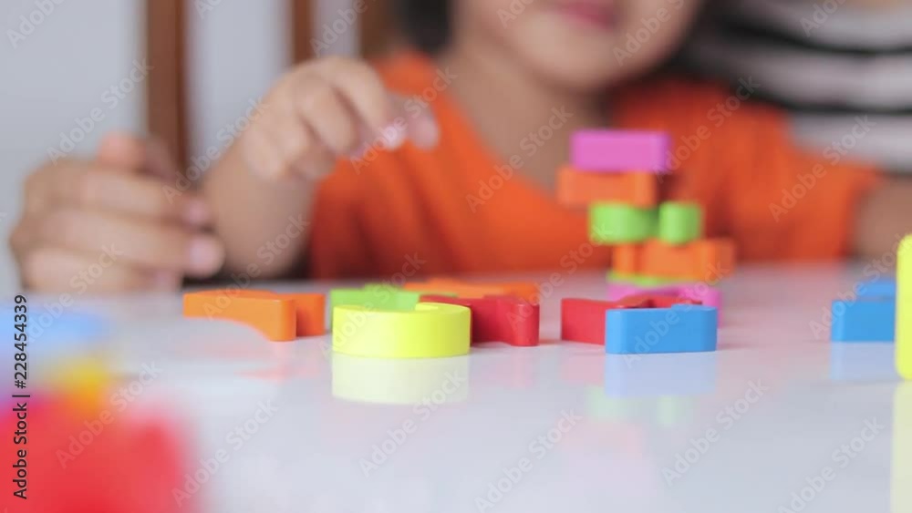 A little boy is playing with alphabet toys mom happily A little boy is playing with alphabet toys mom happily