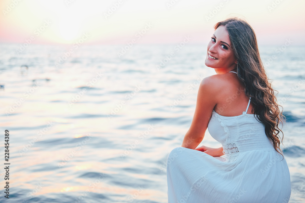 Romantic feminine woman in white dress waiting at the shore Romantic feminine woman in white dress waiting at the shore