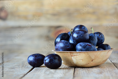 Wallpaper Mural Fresh plums in bowl on wooden background Torontodigital.ca