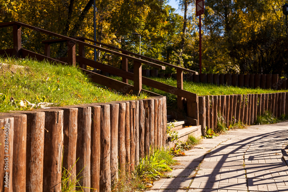 Log fence, wooden staircase and tiled path on the slope in the Park Log fence, wooden staircase and tiled path on the slope in the Park