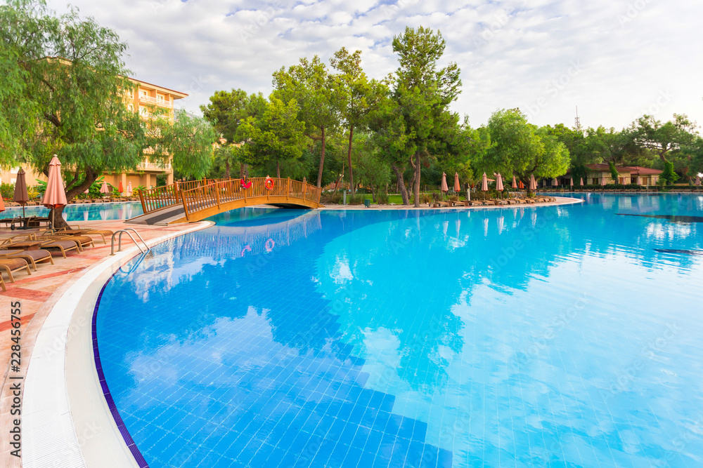 Luxury hotel with a large green area and a huge pool and sun beds around it. Relaxation and luxury beach holidays