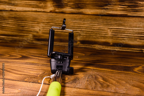 Selfie stick with adjustable clamp on a wooden table