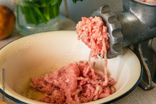 Mincer and mixed chicken and pork mince on a rustic background