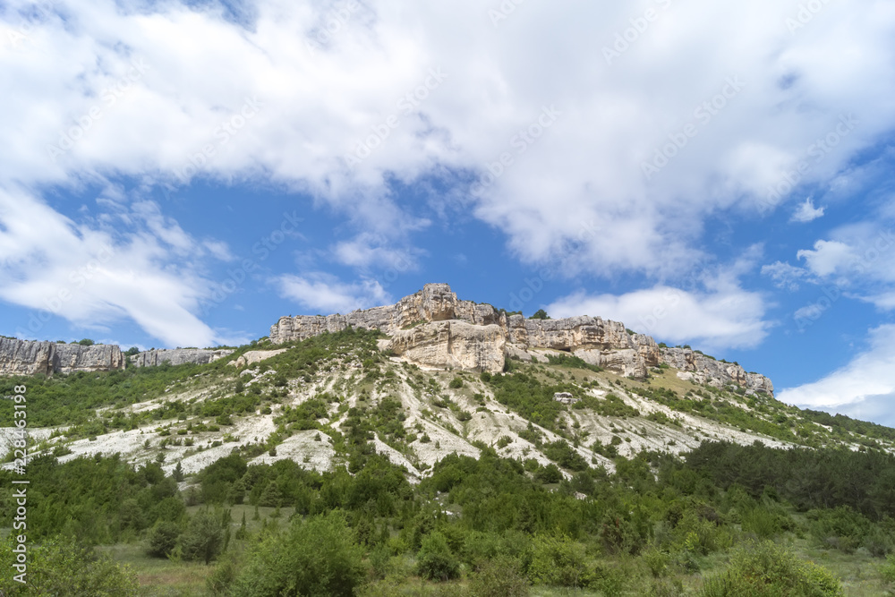 Fototapeta premium Low mountains surrounded by green bushes