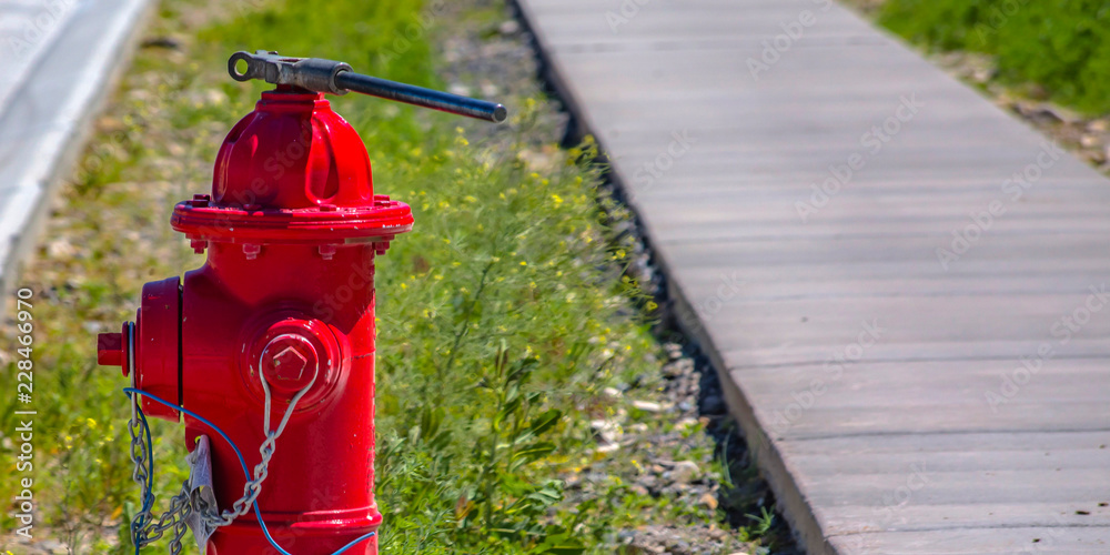 Sunlit fire hydrant with wrench and chain Sunlit fire hydrant with wrench and chain
