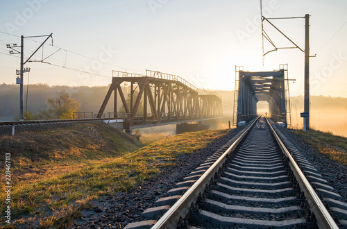 Railway bridge over the Irpin River in the autumn foggy morning.