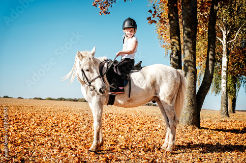 kleines mädchen reitet auf pony