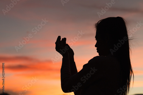 Silhouette of woman hands praying to god with the bible. Woman Pray for god blessing to wishing have a better life. Christian life crisis prayer to god.