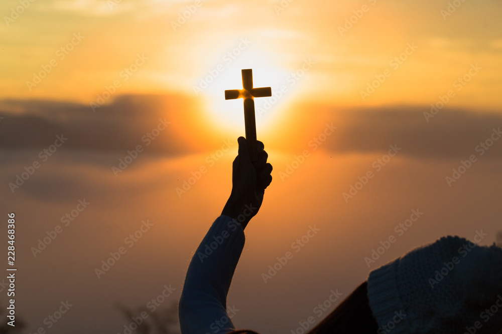 Silhouette of woman  praying with cross  in nature sunrise background,  Crucifix, Symbol of Faith. Christian life crisis prayer to god.