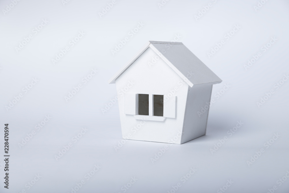 house in winter - heating system concept and cold snowy weather with model of a house wearing a knitted cap house in winter - heating system concept and cold snowy weather with model of a house wearing a knitted cap