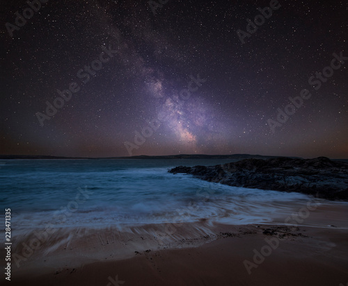 Vibrant Milky Way composite image over landscape of Cornwall coastline in England photo