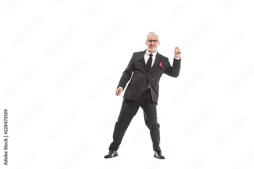 smiling mature businessman in suit with aids awareness red ribbon dancing isolated on white smiling mature businessman in suit with aids awareness red ribbon dancing isolated on white