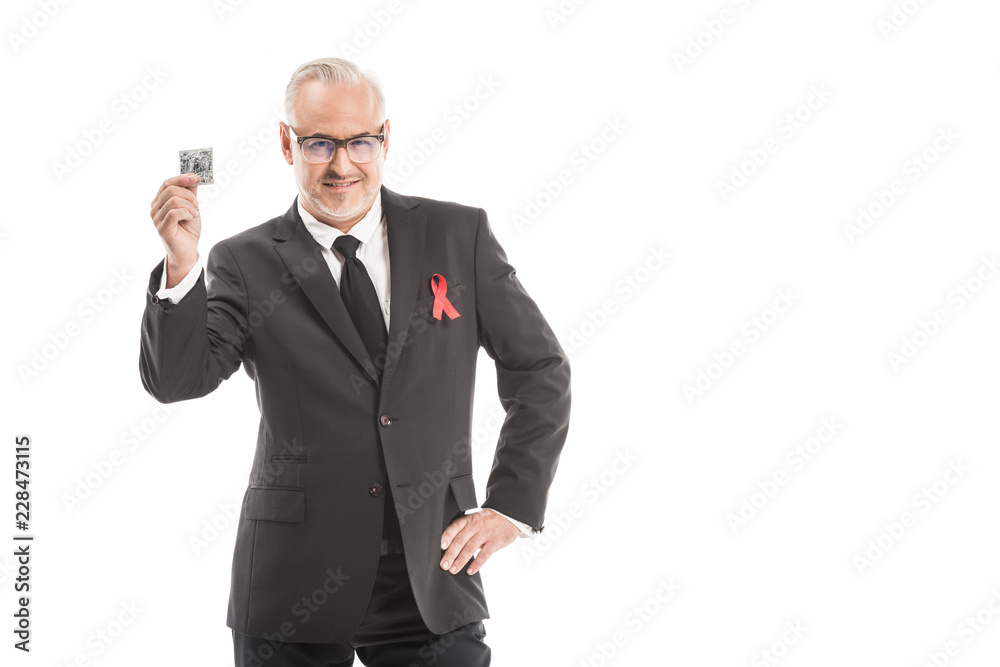 mature businessman in suit with aids awareness red ribbon isolated on white mature businessman in suit with aids awareness red ribbon isolated on white