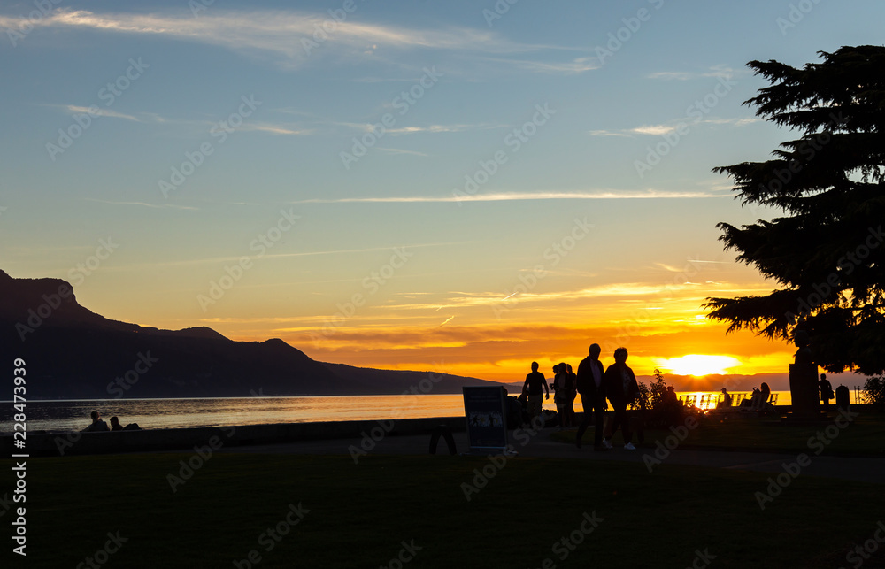 Fototapeta premium Sunset. Silhouette. People. Evening. Lake. Sky