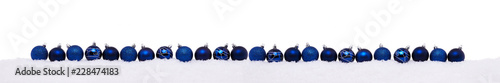 Blue christmas balls in a row isolated on snow, Christmas decoration