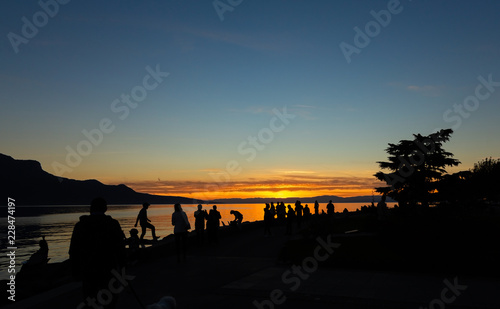 Sunset. Silhouette. People. Sky. Evening. Lake