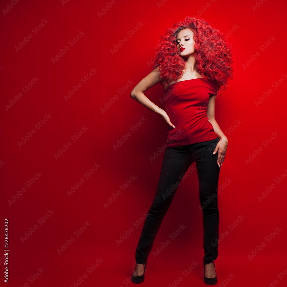 Portrait of beautiful young woman with red hair on red background Portrait of beautiful young woman with red hair on red background