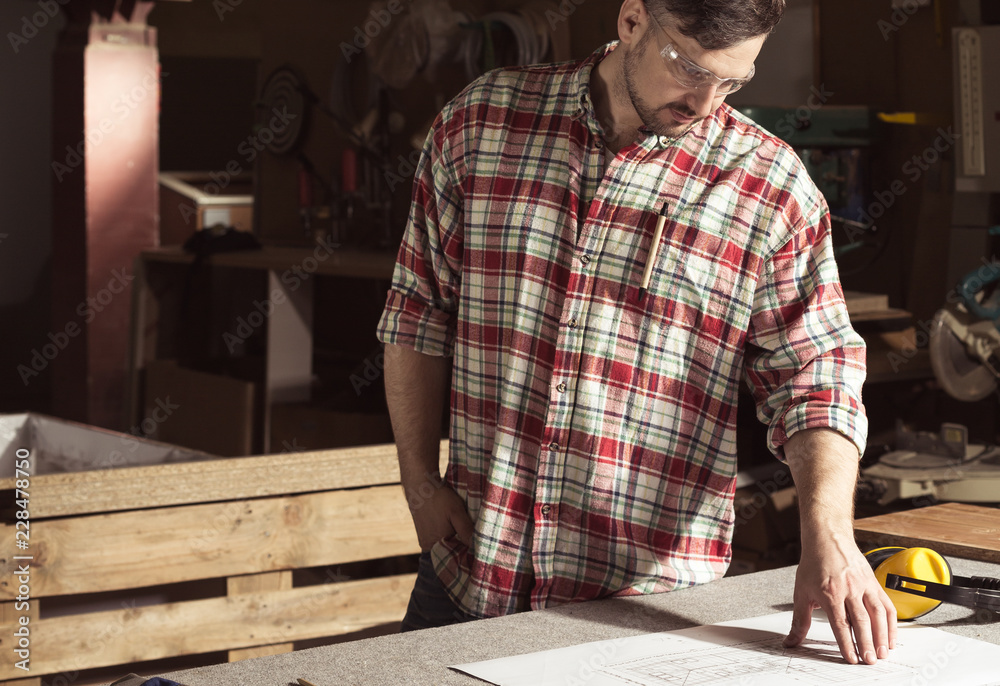 Engineer looking at project in a carpentry shop Engineer looking at project in a carpentry shop