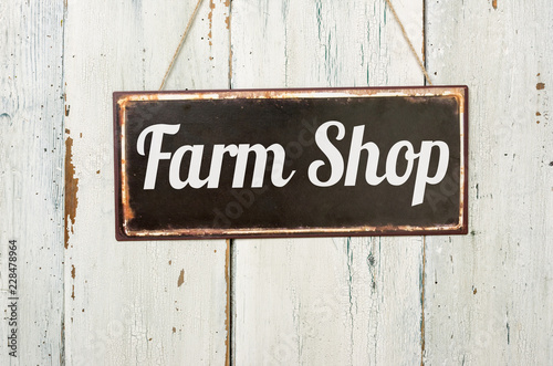 Old metal sign in front of a white wooden wall - Farm Shop