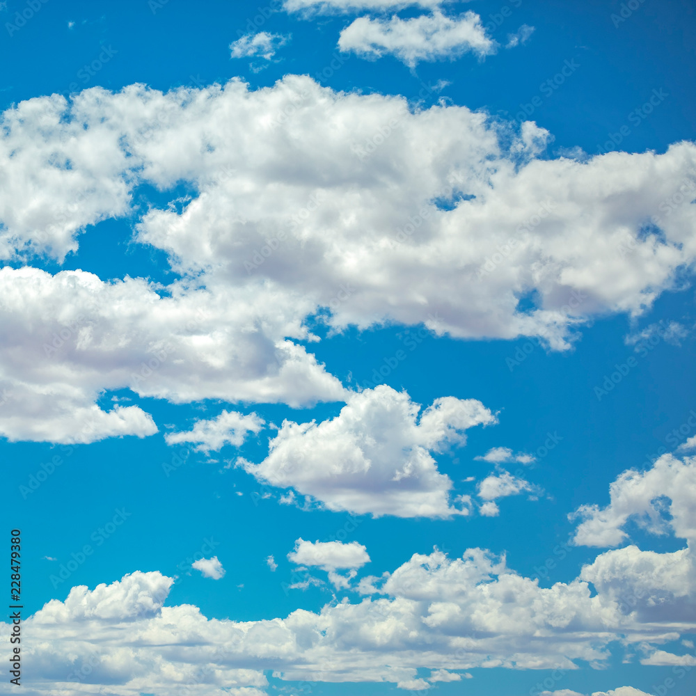 Obraz premium White puffy clouds on a vivid blue sky