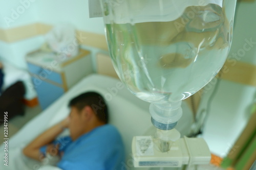 Teenager boy was sick and sleep with equipment IV tube of Infusion pump at hospital,selective focus and space