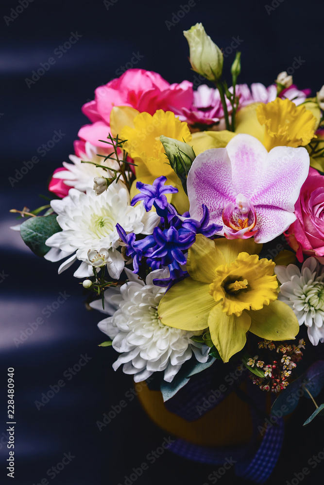 colored bouquet in basket on dark background
