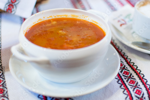 Ukrainian traditional borsch. Russian vegetarian red soup in white bowl on red wooden background. © Konstiantyn Zapylaie