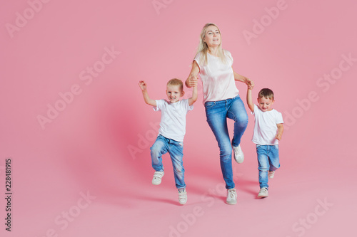 Beautiful blonde mom with two happy sons. Young woman and two baby boys