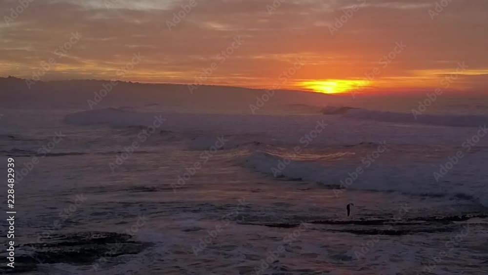 Aerial view of crashing waves during sunset Aerial view of crashing waves during sunset