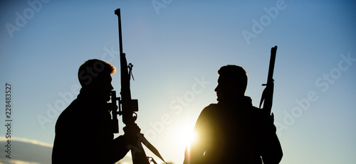 Hunter friend enjoy leisure. Hunting with partner provide greater measure safety fun and rewarding. Hunters friends gamekeepers with guns silhouette sky background. Hunters rifles nature environment