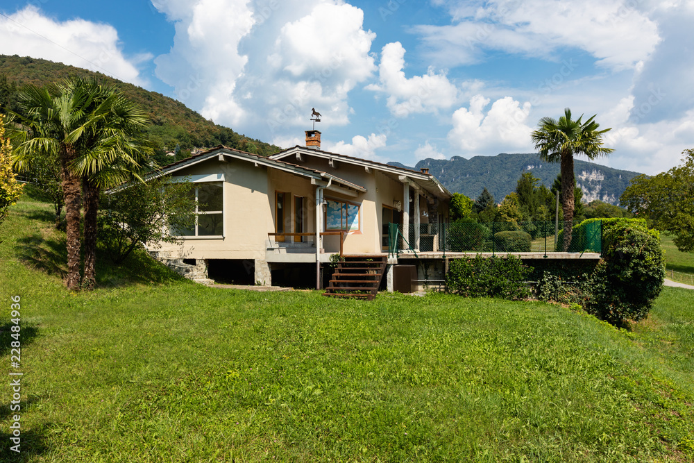 Villa with patio and palm in the countryside surrounded by green lawn Villa with patio and palm in the countryside surrounded by green lawn