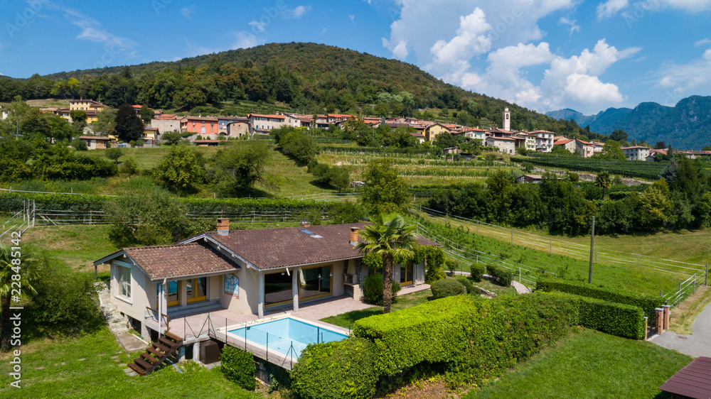 Aerial view of house with swimming pool in the countryside with hills
