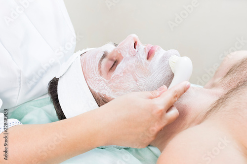 Man in the mask cosmetic procedure in spa salon. 