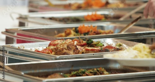People group catering buffet food indoor in luxury restaurant with meat colorful fruits and vegetables. Close up. Banquet, lunch, bad nutrition, gluttony concept photo