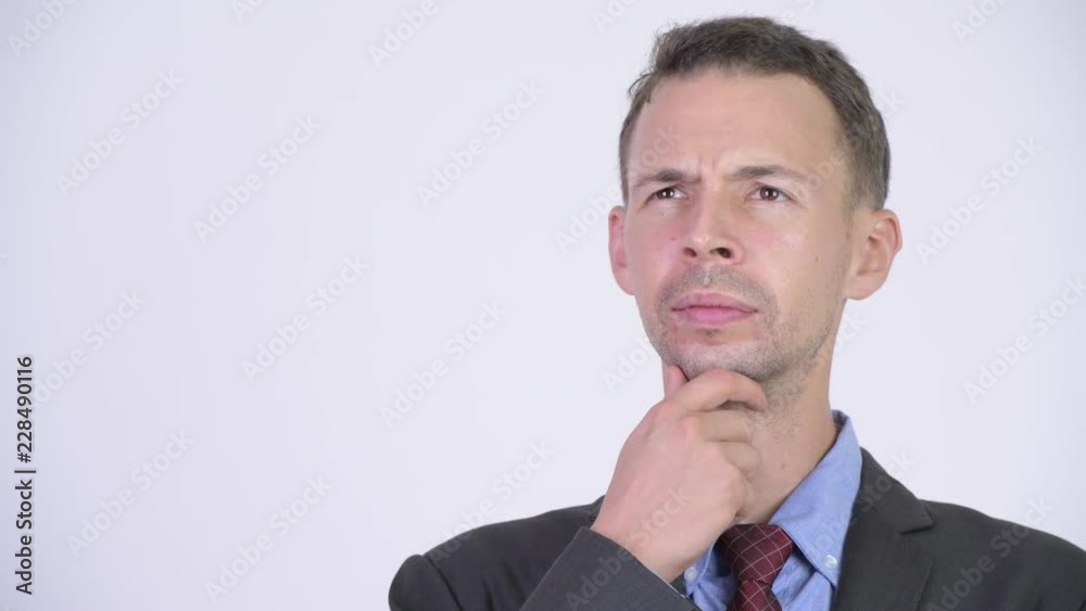 Studio shot of happy businessman smiling while thinking Studio shot of happy businessman smiling while thinking