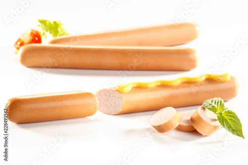 Close-up of frankfurter sausages, weenies with mustard on white background photo