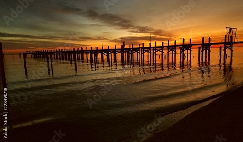pier water calm sunset sunrise sky orange blue