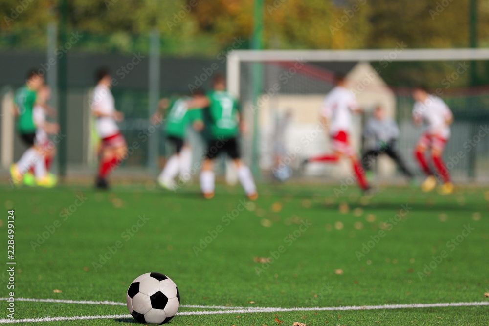 Boys playing a football match and empty space for text