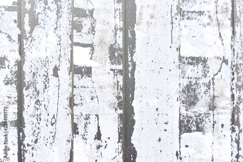 Close-up of vertical strips of white torn paper on a light gray metal background   © Harry Wedzinga