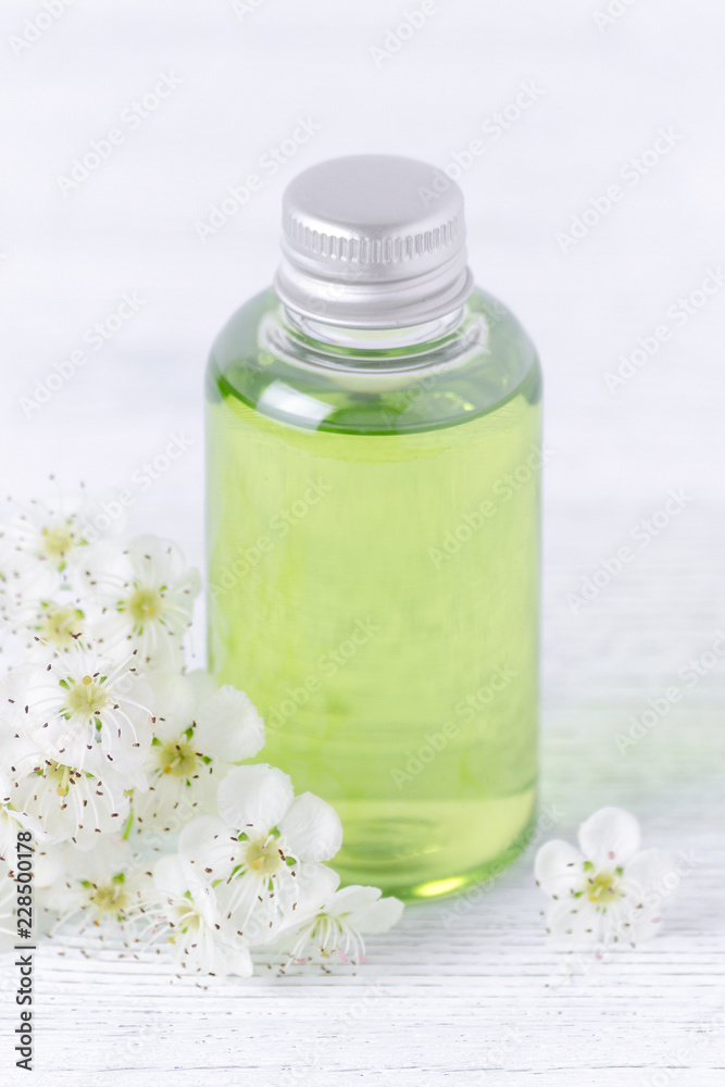a shampoo bottle with fresh flowers, selective focus