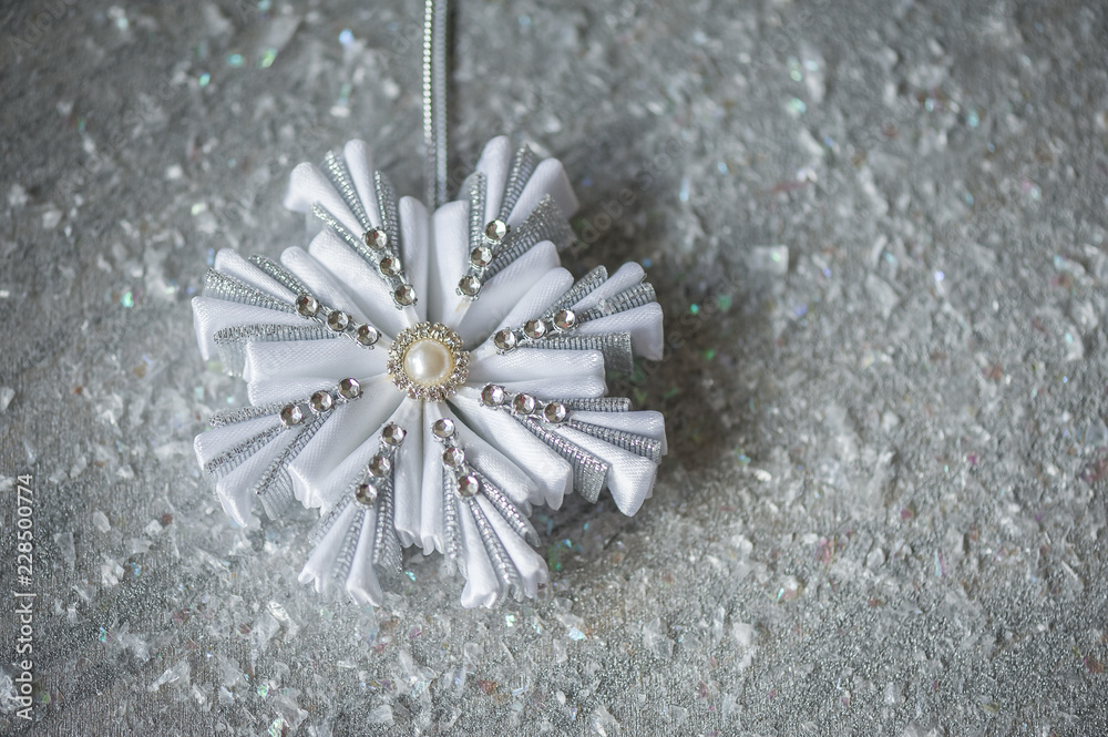 Silver decorative snowflakes on a silver background with snow. Christmas greeting card for the holiday season. Top view. Handmade. Kanzashi snowflake. Copy space. Silver decorative snowflakes on a silver background with snow. Christmas greeting card for the holiday season. Top view. Handmade. Kanzashi snowflake. Copy space.
