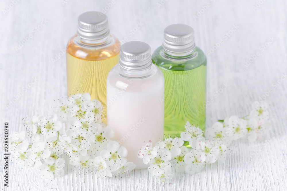 natural cosmetic bottles with fresh flowers, white, green and yellow natural cosmetic bottles with fresh flowers, white, green and yellow