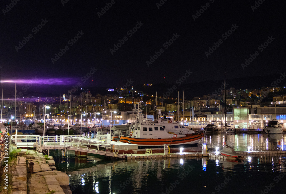 Boats parked in Porto Antico at night