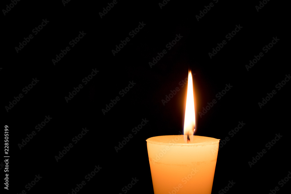 Portrait of one light candle burning brightly on black background. Close-up flame. Portrait of one light candle burning brightly on black background. Close-up flame.