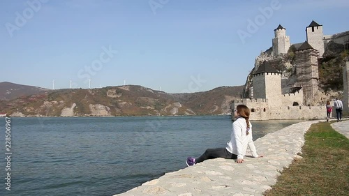 the girl looks at the Golubac fortress on Danube river Serbia