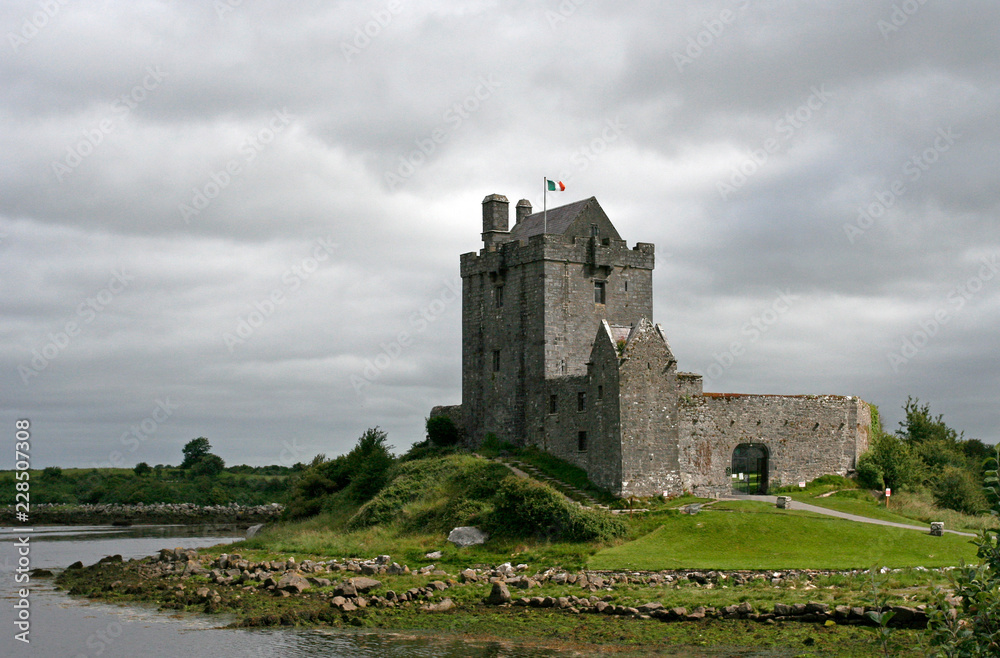 The Dunguaire Castle on the green shore of the Galway Bay on the sunny summer day in Ireland.
